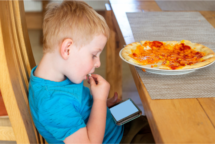 Παιδί που τρώει με το κινητό